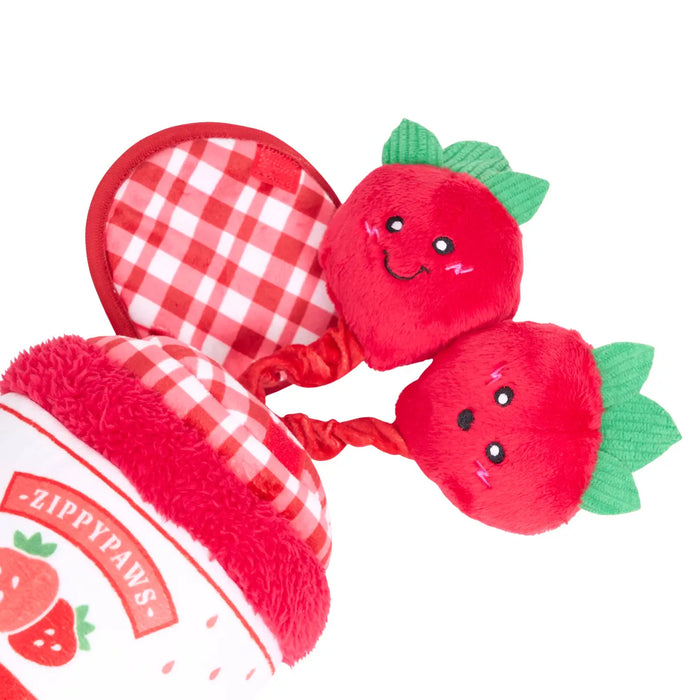 Red strawberry-shaped dog toys with checkered hearts and ZippyPaws branding on a white background