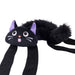 A black cat-shaped plush headband with long black straps, a fluffy tail, purple inner ears, and embroidered facial features on a white background.