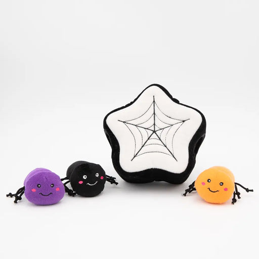 A set of four plush spider toys on a clean white background, including a large star-shaped plush with a spiderweb design in the center and three smaller round spiders in purple, black, and orange with black legs.