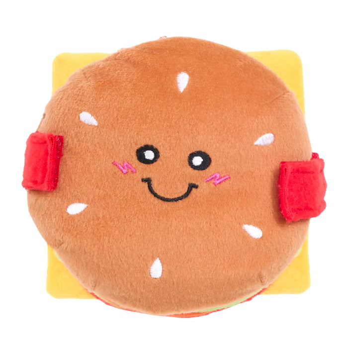 Plush toy shaped like a hamburger with a smiling face on a white background