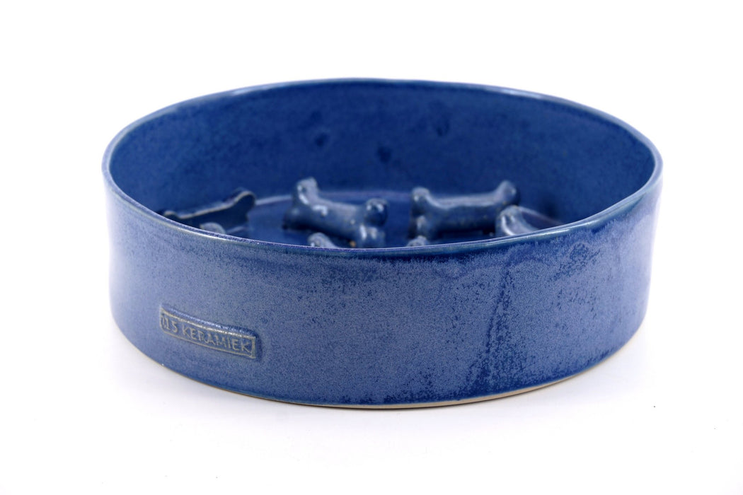 Blue ceramic hand made dog bowl by "015 Keramiek" placed on a white background.