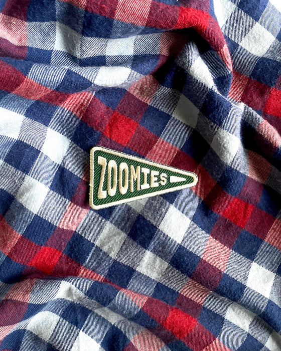Scouts Honour "Zoomies" pennant-shaped iron-on badge in green and white on a checkered pattern backdrop