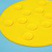 Yellow round lick mat with suction cups on a blue background