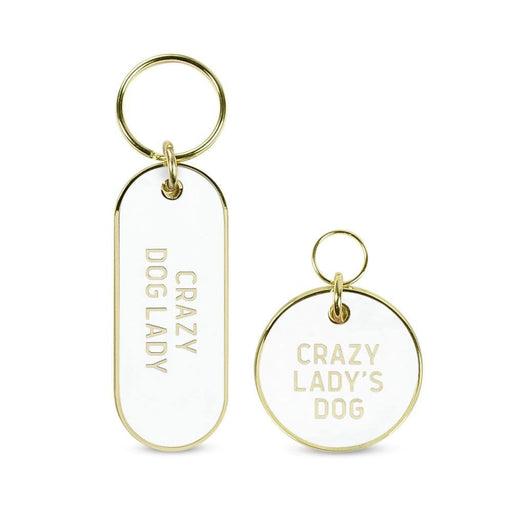 Howligans Keychain set in white enamel and gold details. The set consists of a dog tag and keychains stating: "Crazy Dog Lady" and "Crazy Lady's Dog". The set is pictured on a white background.